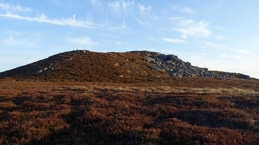 Dawn sky over a rocky rise near the pitch